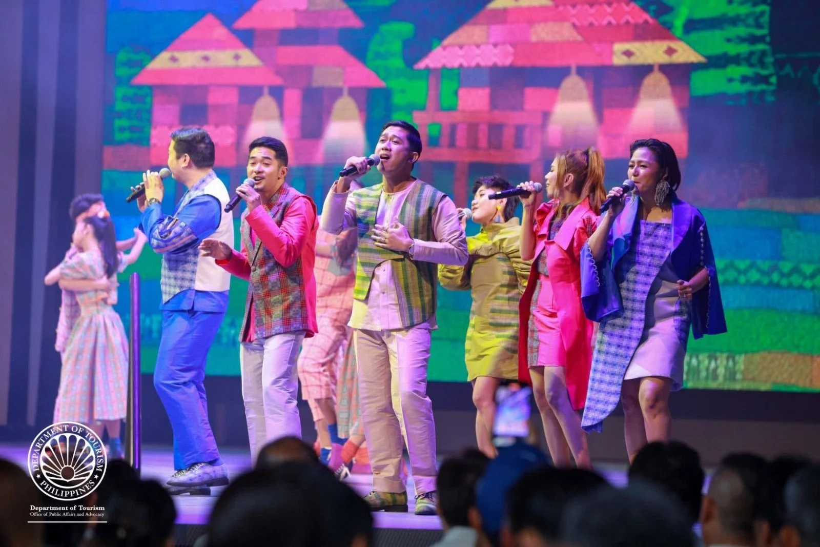 Pinopela singing on a lit stage